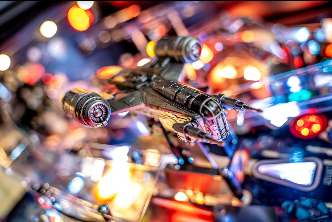 custom made model of the razor crest spaceship from the mandalorian series inside a pinball machine